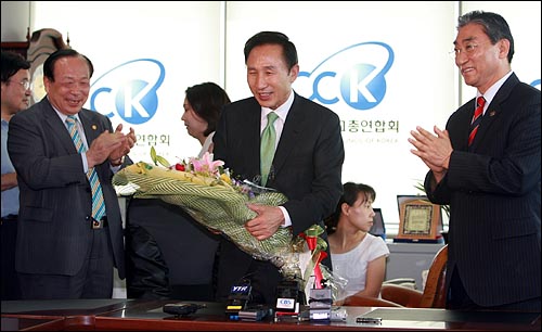 2007년 8월 21일, 서울 연지동 한국기독교총연합회 사무실을 방문한 당시 이명박 한나라당 대통령 후보가 꽃다발을 받고 밝게 웃고 있다.